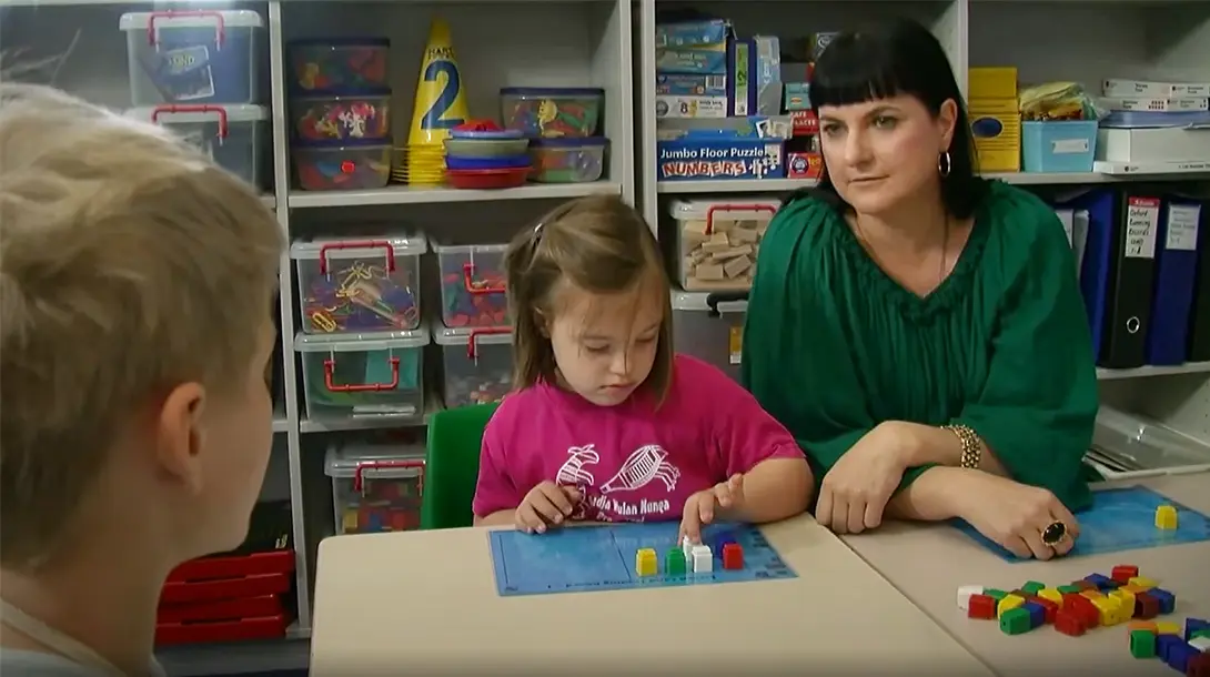A teacher working in a pre-primary and prep room supports students.